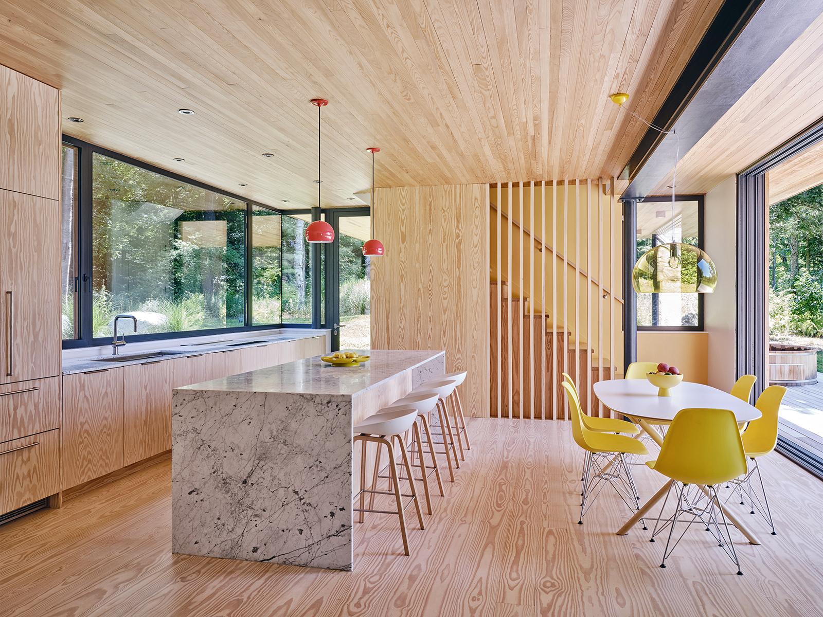 overview of dining area and kitchen in modern passive house addition to new england cottage