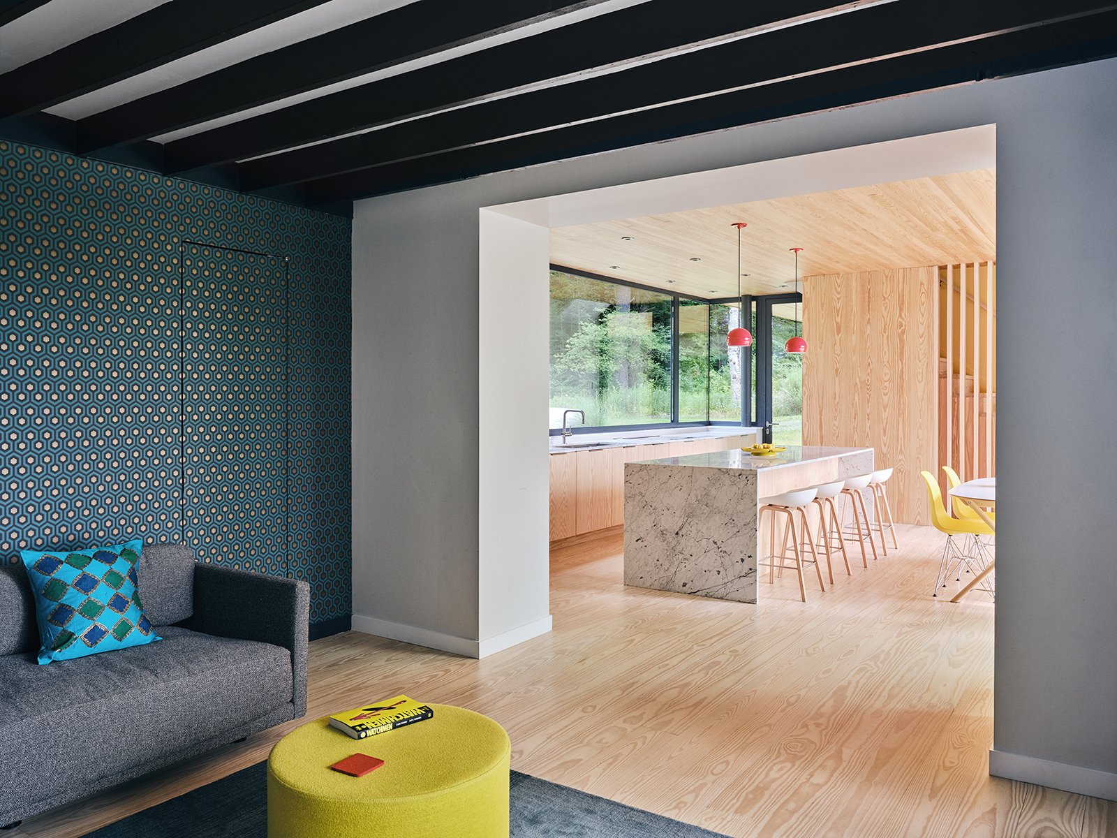 overview of living room, dining area and kitchen in modern passive house addition to new england cottage