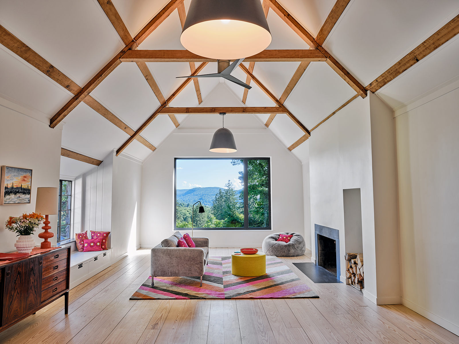 interior living room photo with window view looking over mountains from modern passive home. colorful rug rug and pillow decor accents